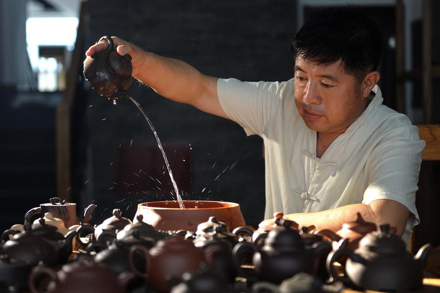 Bai Xuefeng prueba la pieza esmaltada de cerámica de color rojo oscuro casi terminada en su taller en la ciudad de Chaoyang, provincia de Liaoning , 21 de julio.