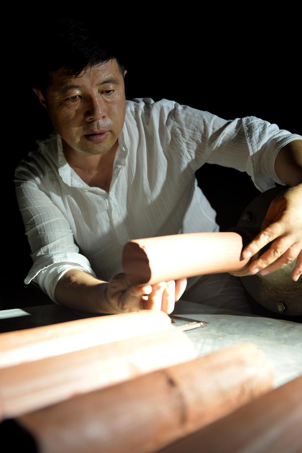 Bai Xuefeng trabaja en una pieza de cerámica de esmalte de color rojo oscuro en su taller en la ciudad de Chaoyang, provincia de Liaoning , 21 de julio.