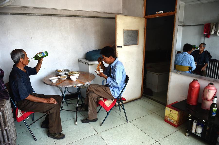 Zhang y su hijo almuerzan en casa. Longhua, Hebei.