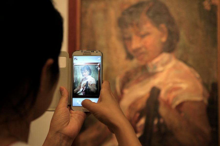 Un visitante le toma una foto a una obra de Si Tuqiao.