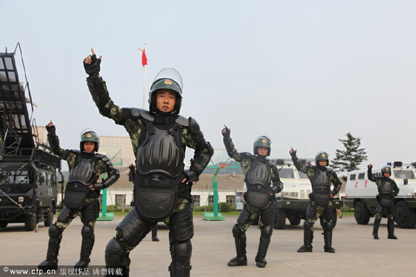 Policías armados hacen el baile de la canción 'Manzanita' en la ciudad de Jilin, provincia de Jilin, el 29 de julio de 2014. [Foto/CFP]