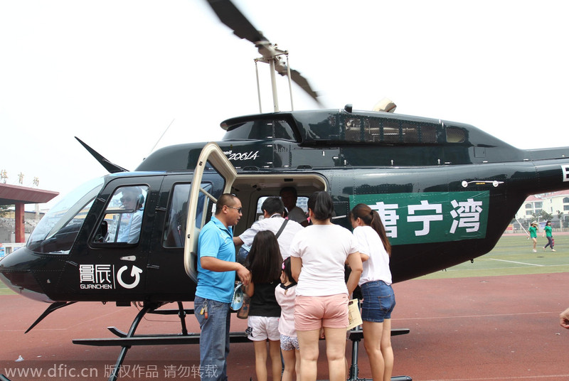 Los potenciales clientes abordan un helicóptero para ir a ver las propiedades en venta. Changge, Henan. 16 de agosto de 2014. [Foto/IC] 