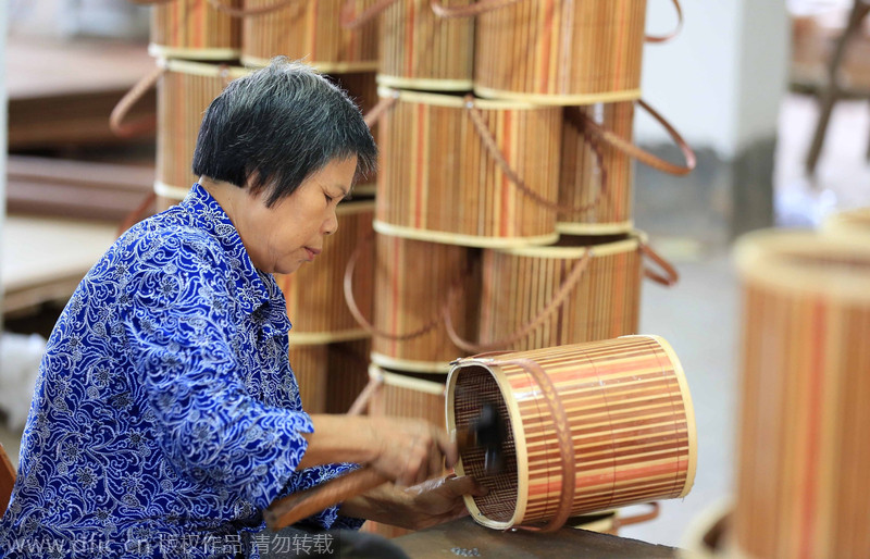 Una trabajadora fabrica una caja de regalo. Rongan, Liuzhou, Guangxi Zhuang. 18 de agosto de 2014. [Foto/IC]