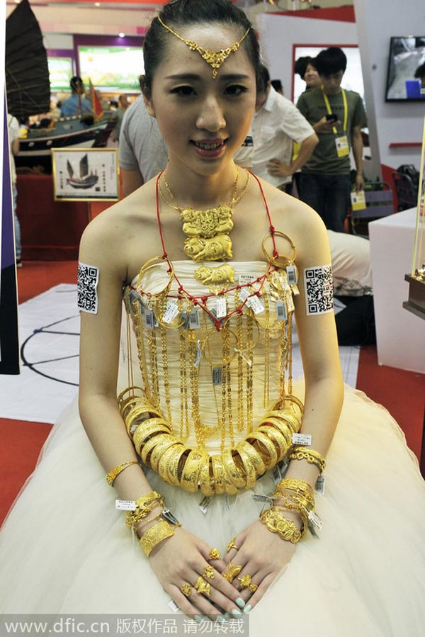 Modelo viste un vestido de novia con más de 3,5 kg de oro en una convención, el 18 de junio de2014. [Foto/IC]