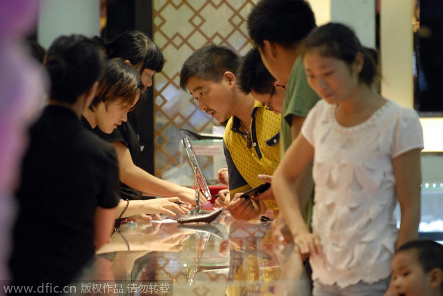 Vendedores atienden a clientes en una joyería de la provincia de Anhui, el 2 de agosto de 2014. [Foto/IC]