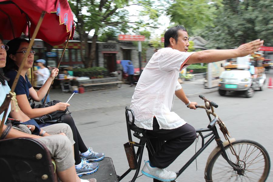 Cao Junlai cuenta historias de los hutones a los turistas en Pekín, el 12 de septiembre de 2014. 