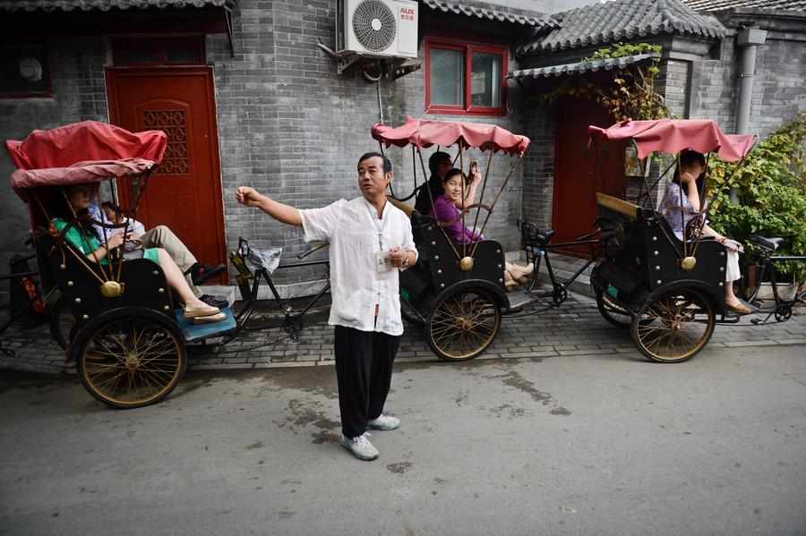 Cao Junlai explica la historia de los hutones a los turistas en Pekín, el 12 de septiembre de 2014.