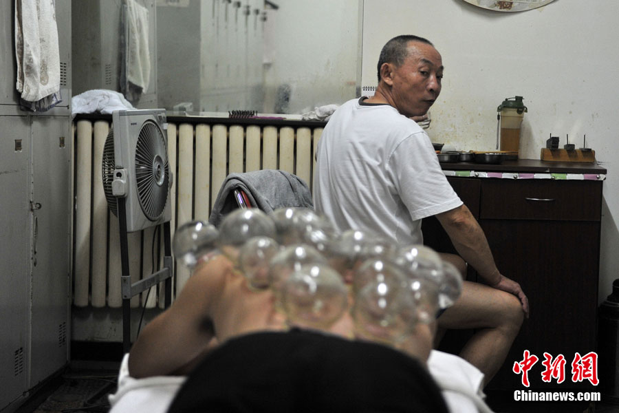 Tian, que trabaja en el Baño Xinyuan, ofrece una terapia de medicina tradicional china a un cliente. 