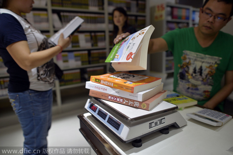 Un empleado pesa los libros que vende por kilogramos. Chongqing. [Foto/IC]