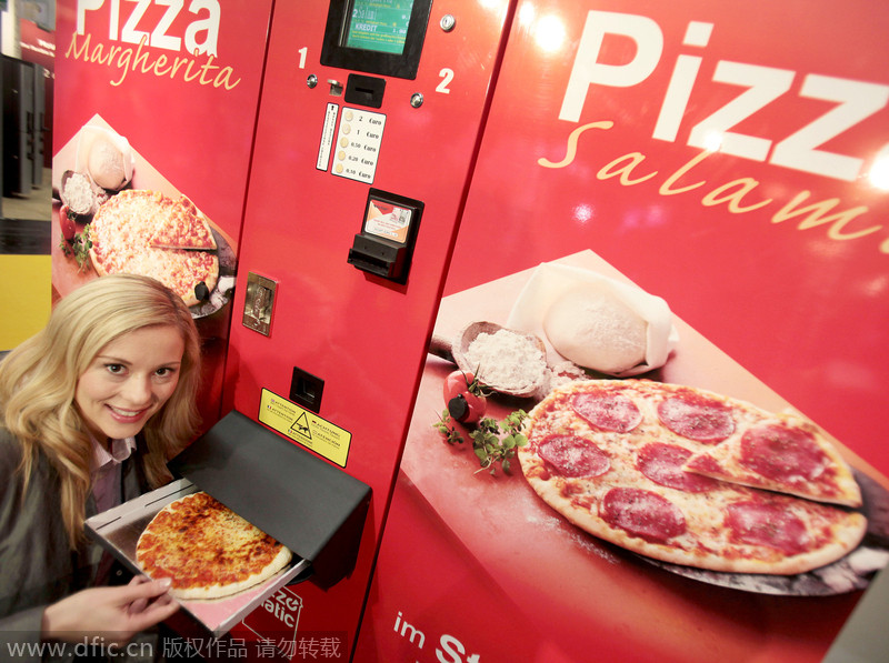 Una modelo muestra una pizza que ha comprado en una máquina expendedora. Colonia, Alemania. [Foto: IC]
