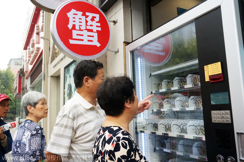 Comensales compran cangrejos peludos vivos, situados en una máquina expendedora. Hangzhou, China. [Foto: IC] 