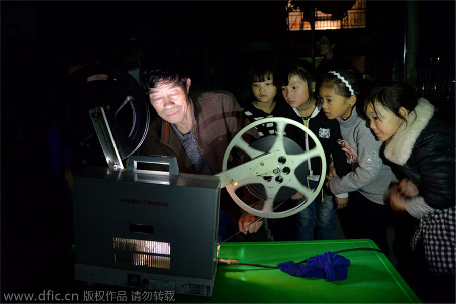 Los niños observan Wei operando el proyector durante el espectáculo. [Foto / IC]