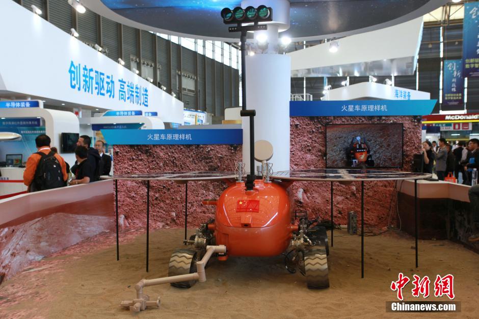 El prototipo del vehículo automatizado Mars Rover (el explorador de Marte) de fabricación China atrae a los visitantes en Shanghai, durante la Feria Internacional Industrial 2014. Sobre la base tecnológica del primer vehículo lunar chino, conocido como "Conejo de Jade", el Instituto de Investigaciones de Ingeniería Aeroespacial de Shanghai, en colaboración con otros institutos extranjeros, llevó a cabo la investigación, desarrollado numerosos prototipos digitales. [Foto/CNS]