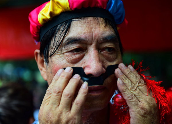 Chen Bin, de 73 años, comprueba su maquillaje antes de una presentación de baile. [Foto: PPC]