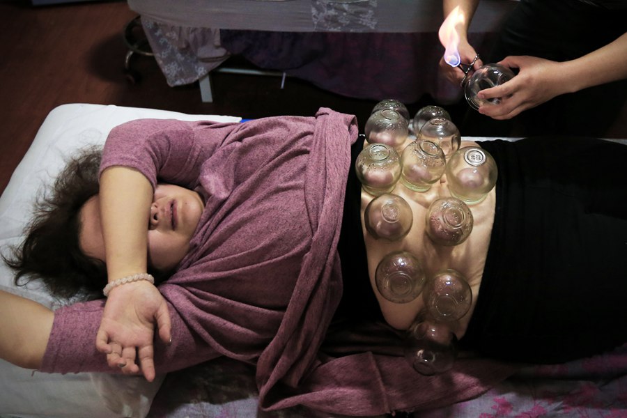 En un centro de masajes, Taozi se somete al tratamiento con ventosas, un método de la medicina tradicional china para curar diversos problemas de salud. [Foto: PPC]
