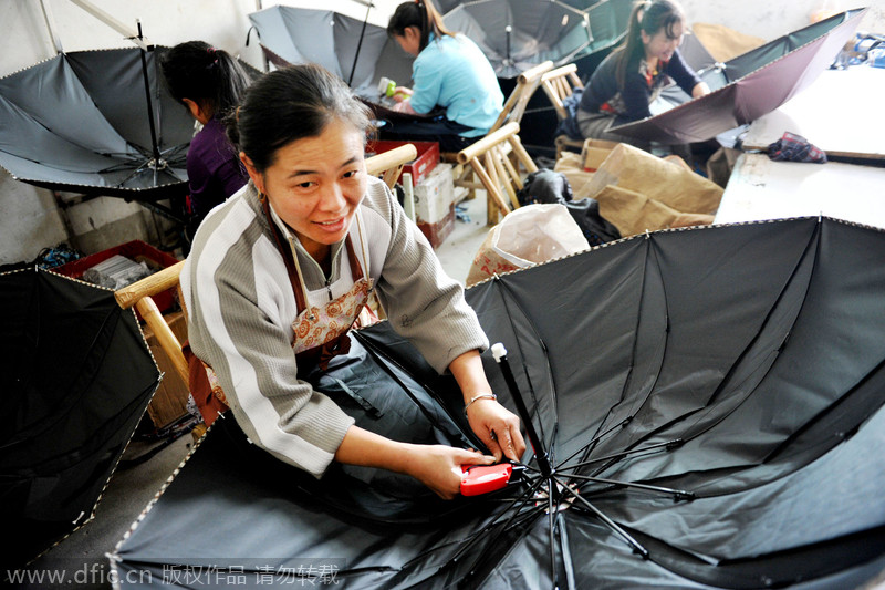 Una trabajadora une las partes del interior del paraguas antes de exportarlo al sudeste asiático en un pueblo de la ciudad de Dexing, en la provincia de Jiangxi, el 29 de noviembre de 2014. [Foto/IC]