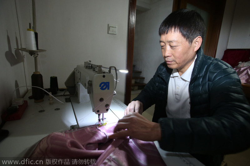 Xu cose ropa a mano en su casa de Shanghai. [Foto/IC]