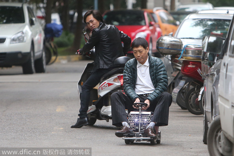Transeúnte observa a Xu conduciendo su mini coche por las calles de Shanghai, el 2 de diciembre de 2014. [Foto/IC]
