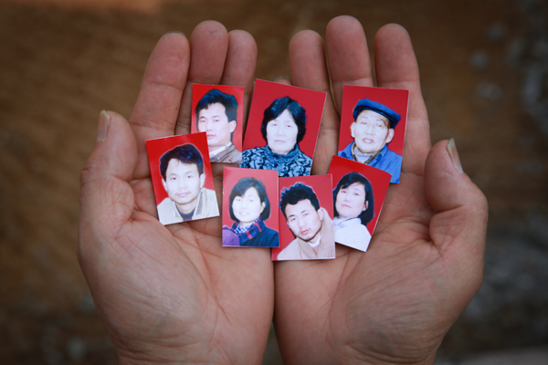 Zhu Chunran muestra las fotos de su suegro Wang Jiayun, su suegra y sus 5 hijos, quienes murieron envennados por arsénico, lo que además ha condenado a padecer y morir de cáncer a más de 400 trabajadores de una mina de la aldea Heshan, en el distrito Shimen, Changde, Hunan. [Foto: IC]