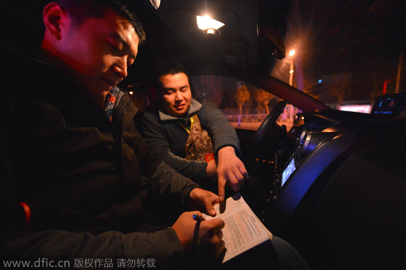 El conductor privado Li Xiaodong pide a un cliente que rellenar un formulario en Shijiazhuang, provincia de Hebei, el 17 de diciembre de 2014. [Foto/IC]
