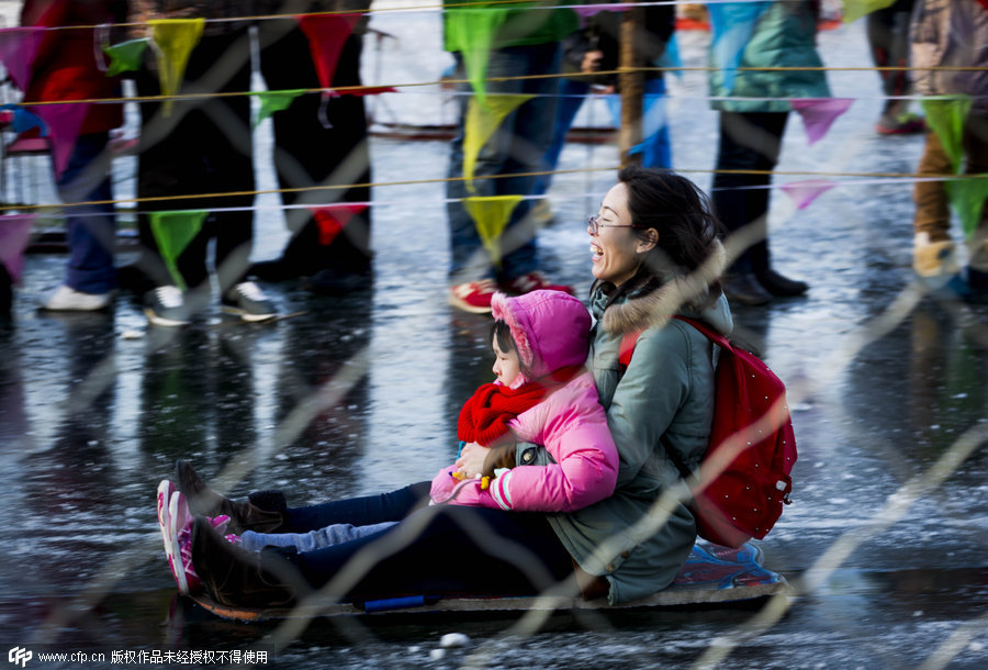 Una madre se divierte con su hija en un trineo de hielo. [Foto/CFP]