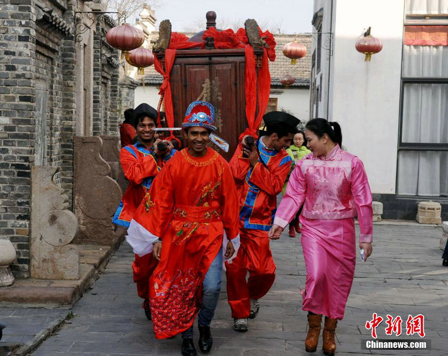 Más de 100 estudiantes extranjeros procedentes de 26 países viven la experiencia de una auténtica boda al estilo Qing, en la región de Huizhou, el 18 de enero de 2015.