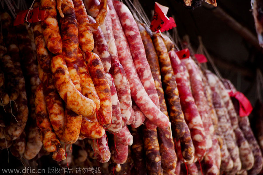 Embutidos colgados para que se sequen en una tienda de alimentos de Shanghai, el 6 de enero de 2014. [Foto/IC]