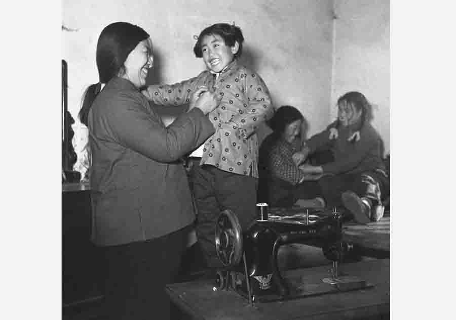En 1954, una chica llamada Xiao Cui se viste con la ropa nueva hecha por su mamá cuando se aproxima el año nuevo en la provincia de Hebei. [Photo/ Xinhua]