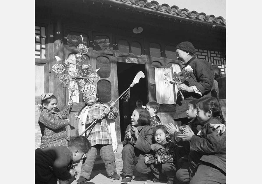 Una mujer mayor, de apellido Yang, mira a sus nietos jugando durante la Fiesta de la Primavera de 1956.