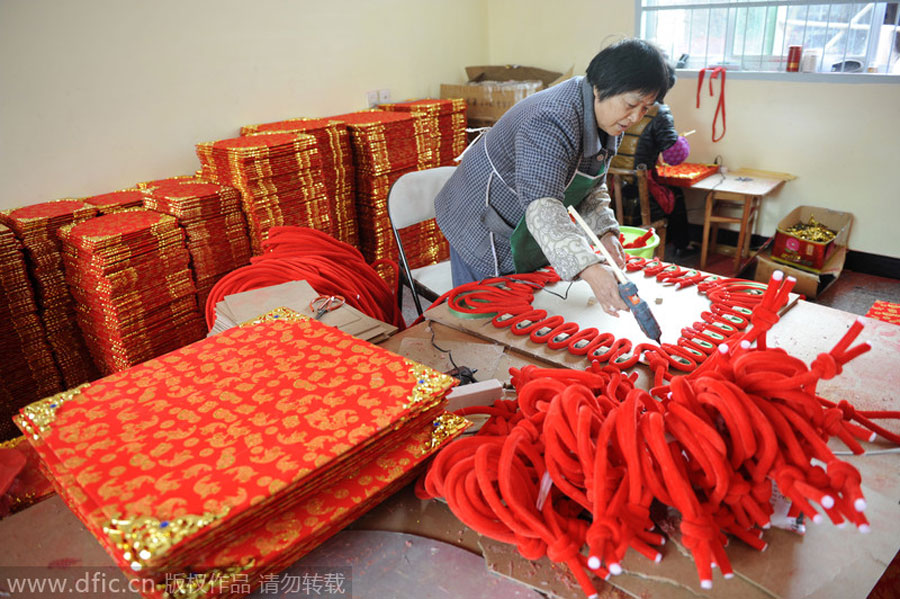 Producción de lazos rojos de la buena suerte, en Huashui, ciudad de Dongyang, provincia de Zhejiang, el 26 de noviembre de 2013. [Foto/IC]