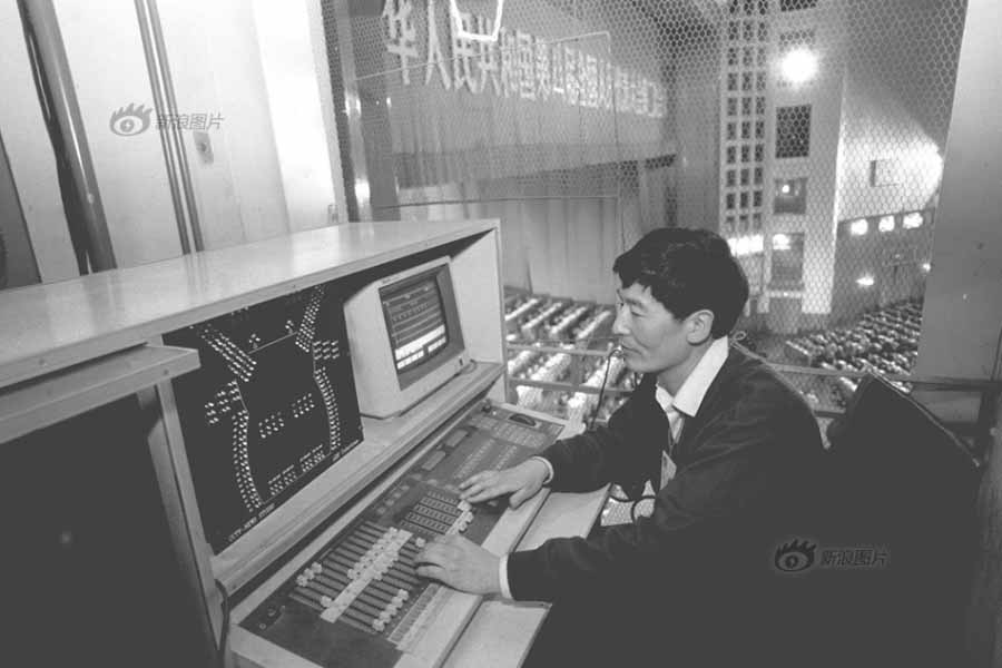 Esta foto tomada en 1994 muestra a Cao, miembro del equipo de iluminación de CCTV, ajustando la iluminación en el Gran Salón del Pueblo en Pekín. (Foto: Liu Jiansheng)