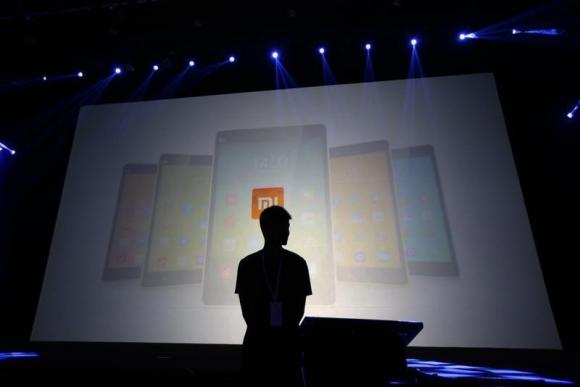 Un guardia de seguridad frente a una pantalla que muestra los teléfonos Xiaomi antes de la ceremonia de lanzamiento del Xiaomi 4 en Pekín, el 22 de julio de 2014. [Foto/agencias]