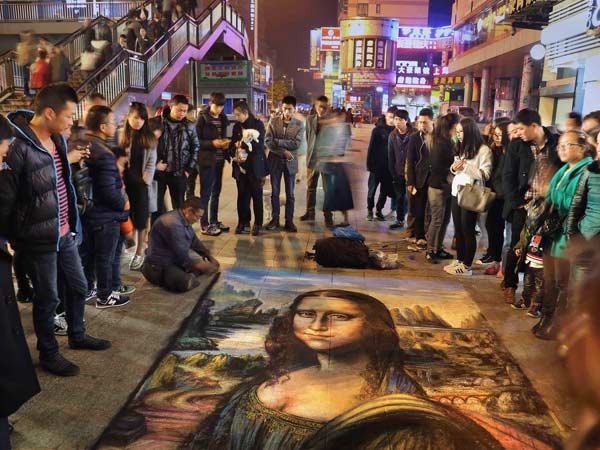 Un hombre discapacitado pintó la Mona Lisa en una calle de Jinhua, provincia de Zhejiang, el 9 de abril de 2015.