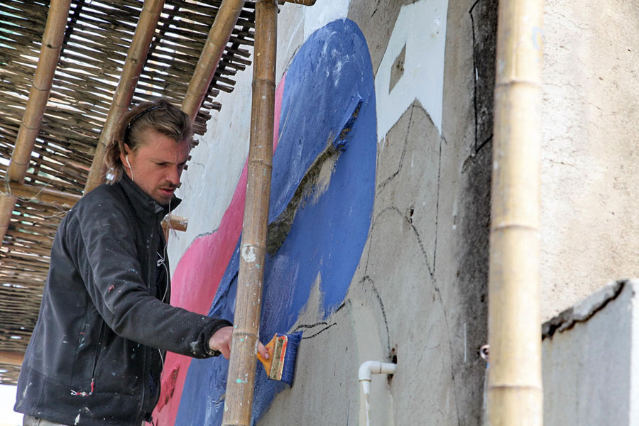 El artista francés Julien Seth Malland pinta una pared en una aldea del pueblo Fengjing en el distrito Jinshan de Shanghai. El parisino de 42 años pintará 10 obras en el pueblo en las próximas dos o tres semanas. [Foto/Xinhua] 
