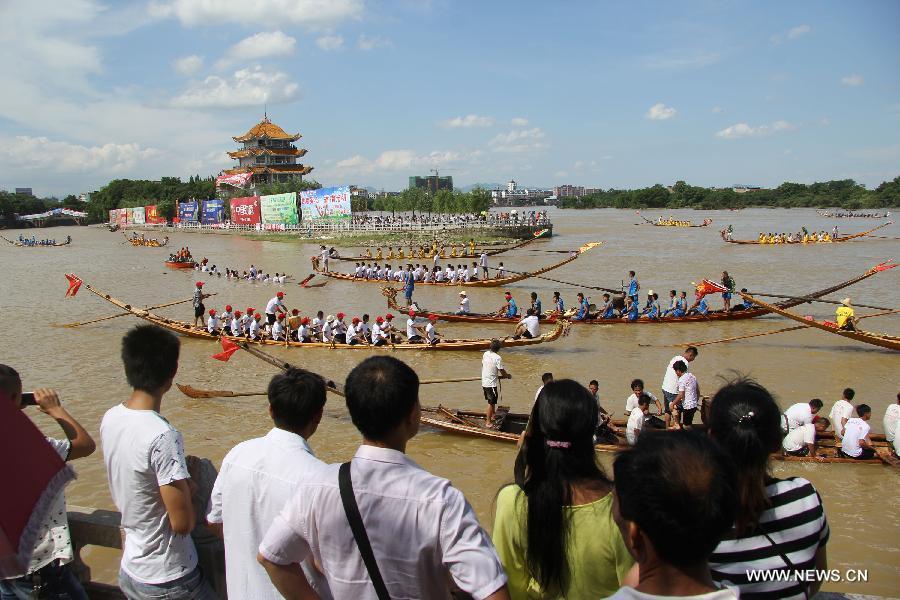 Los competidores reman en los barcos de dragón durante una carrera celebrada en el río Xiaoshuihe para celebrar el Festival del Barco de Dragón en Yongzhou, provincia de Hunan, el 16 de junio de 2015. [Foto/Xinhua]