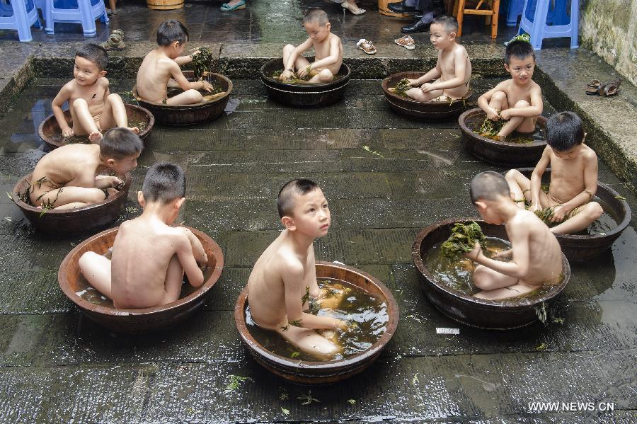 Los niños se bañan en agua con ajenjo para celebrar el Festival del Barco de Dragón en Zigui, provincia de Hubei, el 16 de junio de 2015. [Foto/Xinhua]