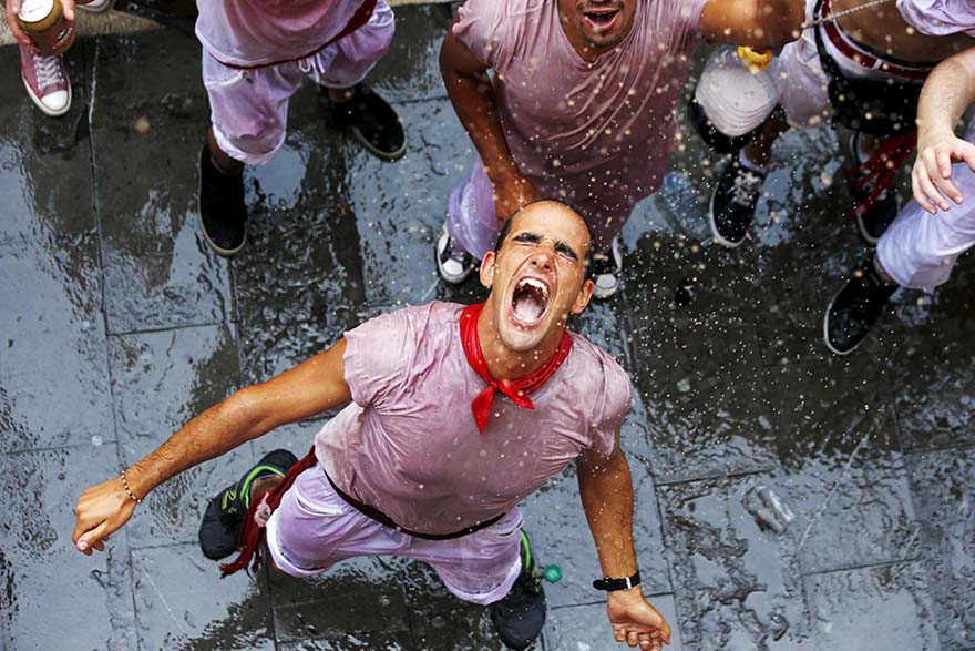 La gente se moja durante el inicio de la fiesta de San Fermín en Pamplona, España, el 6 de julio de 2015. El festival, más conocido por las carreras diarias junto a los toros, arrancó el lunes con el lanzamiento del tradicional "Chupinazo" y durará hasta el 14 de julio. [Agencias de fotografía]