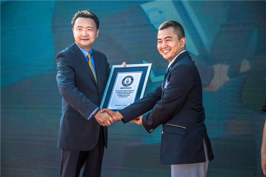 Billy Chen, a la izquierda, director general del hotel Sheraton Langfang Chaobai River, recibe el certificado de Cheng Dong, oficial de certificados de Guinness World Records. [Foto chinadaily.com.cn]