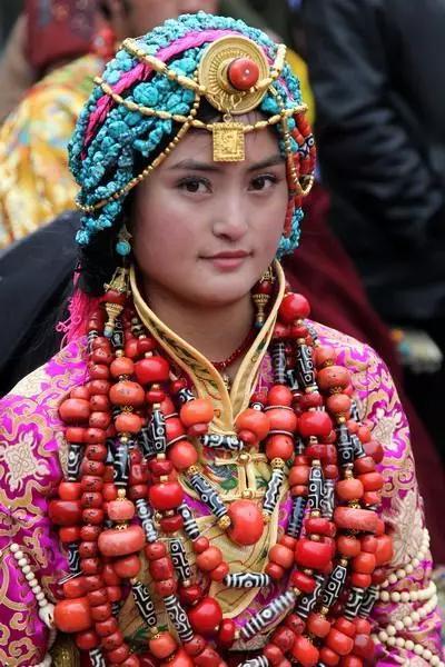 Una mujer tibetana lleva adornos exagerados que incluyen joyas costosas. [Foto/Yidianzixun.com]