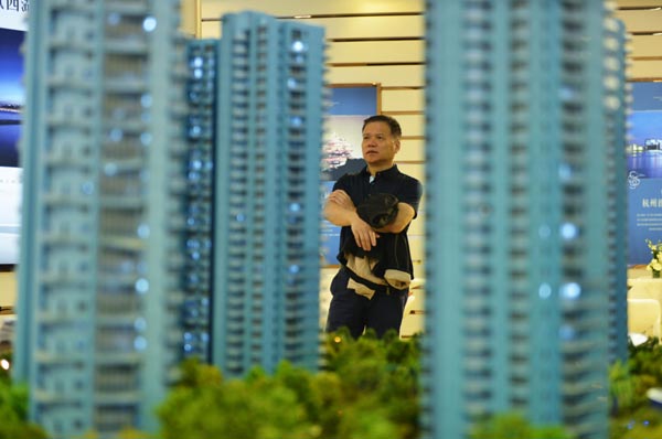 Un hombre observa maquetas de propiedades en uncentro de ventas de vivienda en Hangzhou, capital de la provincia de Zhejiang. [Foto / China Daily]