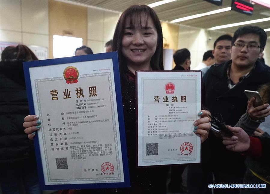 La foto tomada el pasado 26 de marzo del año 2015 muestra a Li Xia, representante legal de una empresa de la provinica de Jiangxi mostrando su licencia de negocio y la copia que acababa de obtener. China ha reducido los trámites burocráticos y el tiempo necesario para obtener una aprobación. 