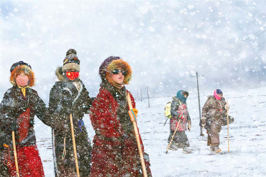 Peregrinos del budismo tibetano caminan a través de la nieve. [Fotografía de Hu Guoqing/photoint.net]