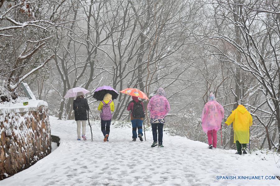 Gente escalan una montaña en la nieve en Nanjing, capital de la provincia de Jiangsu, este de China, enero 22, 2016. La estación central Meteoical emitió alerta amarilla para el brote de aire frío viernes. (Xinhua / Wang Yuewu)