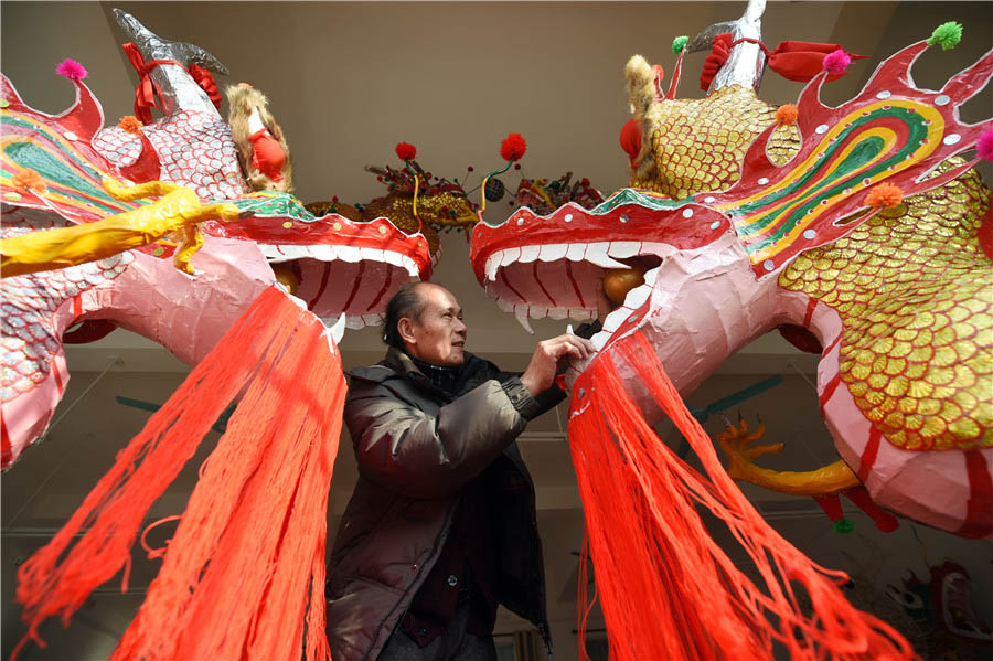 Zou Yute adorna un farolillo de dragón en el condado Binyang, región autónoma Zhuang de Guangxi, el 16 de febrero de 2016. [Foto/Xinhua]