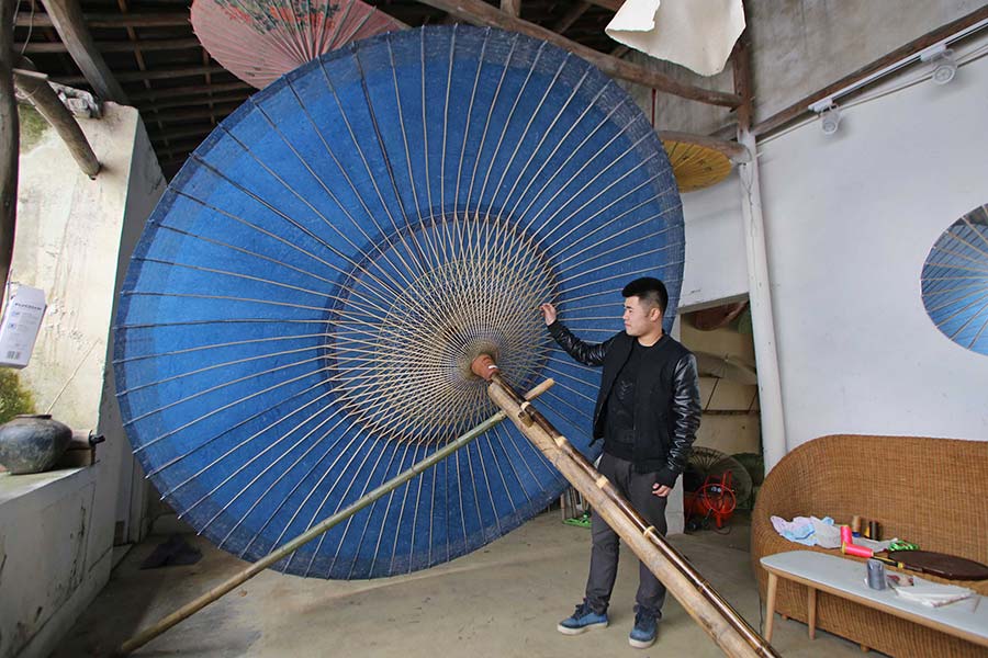 Liu Weixue muestra una sombrilla de papel de Yuhang en la aldea de Tangbu, distrito de Yuhang en Hangzhou, provincia de Zhejiang.
