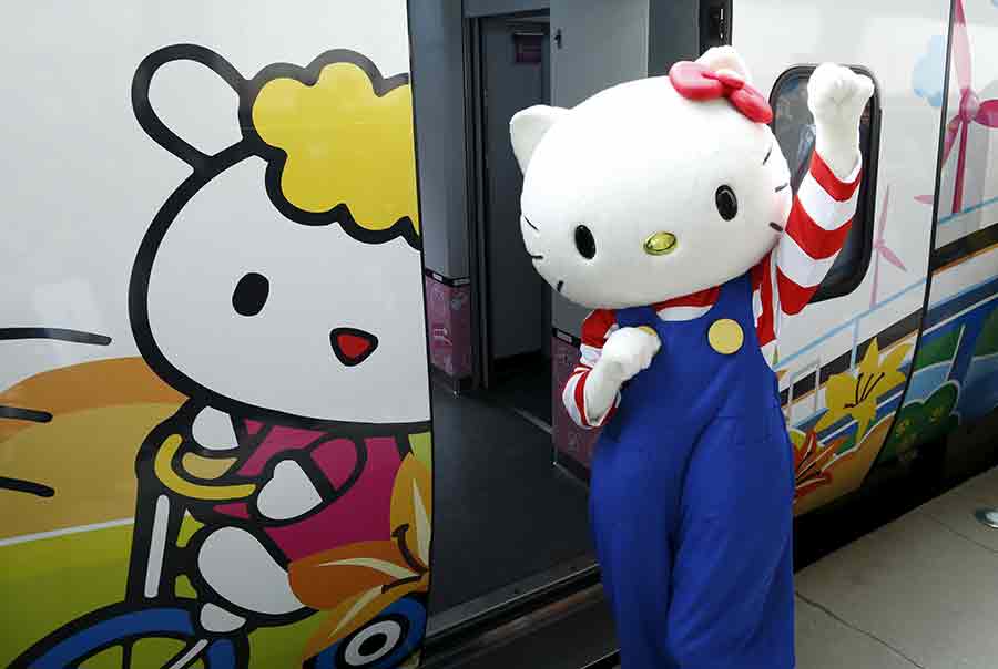 Un empleado disfrazado de Hello Kitty posa junto al tren Taroko Express con temática de Hello Kitty en Taipei, el 21 de marzo de 2016. [Foto/Agencias]