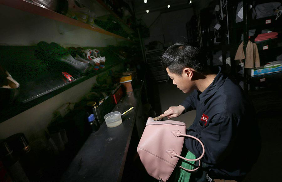 Un empleado limpia un bolso de cuero en Chengdu, provincia de Sichuan, el 23 de marzo de 2016. 