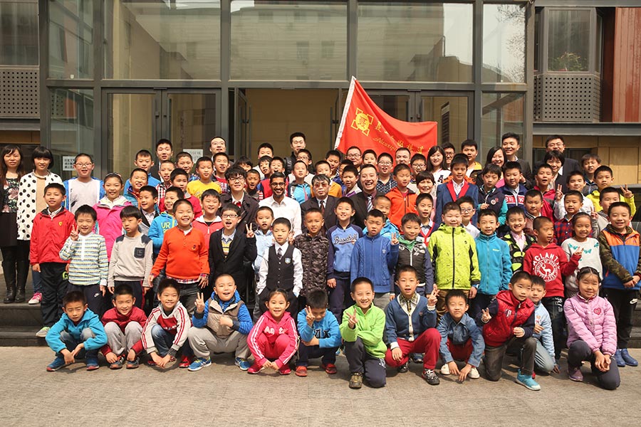 El presidente ejecutivo de Google, Sundar Pichai, se hace una foto en grupo con los niños de la Escuela Go Nie Weiping en Beijing, el 31 de marzo de 2016. [Foto de China Daily]