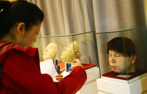 Una visitante fotografía una cabeza humana creada con tecnología 3D en la funeraria Longhua de Shanghai, China, el 30 de Marzo de 2016.