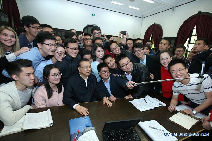 El primer ministro de China, Li Keqiang, se toma una "selfie" con estudiantes en la biblioteca de la Universidad de Tsinghua, en Beijing, capital de China, el 15 de abril de 2016. Li Keqiang visitó el viernes las Tsinghua y Pekín, dos universidades de prestigio de Beijing, para inspeccionar sobre el desarrollo de la reforma educativa y la implementación de la estrategia de desarrollo impulsada por la innovación. (Xinhua/Pang Xinglei)